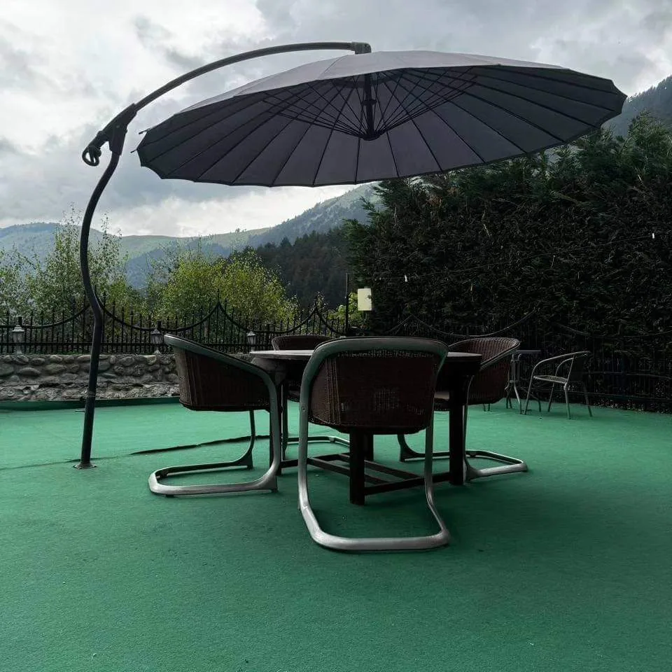 Outdoor seating with parasol at Villa Bjeshka