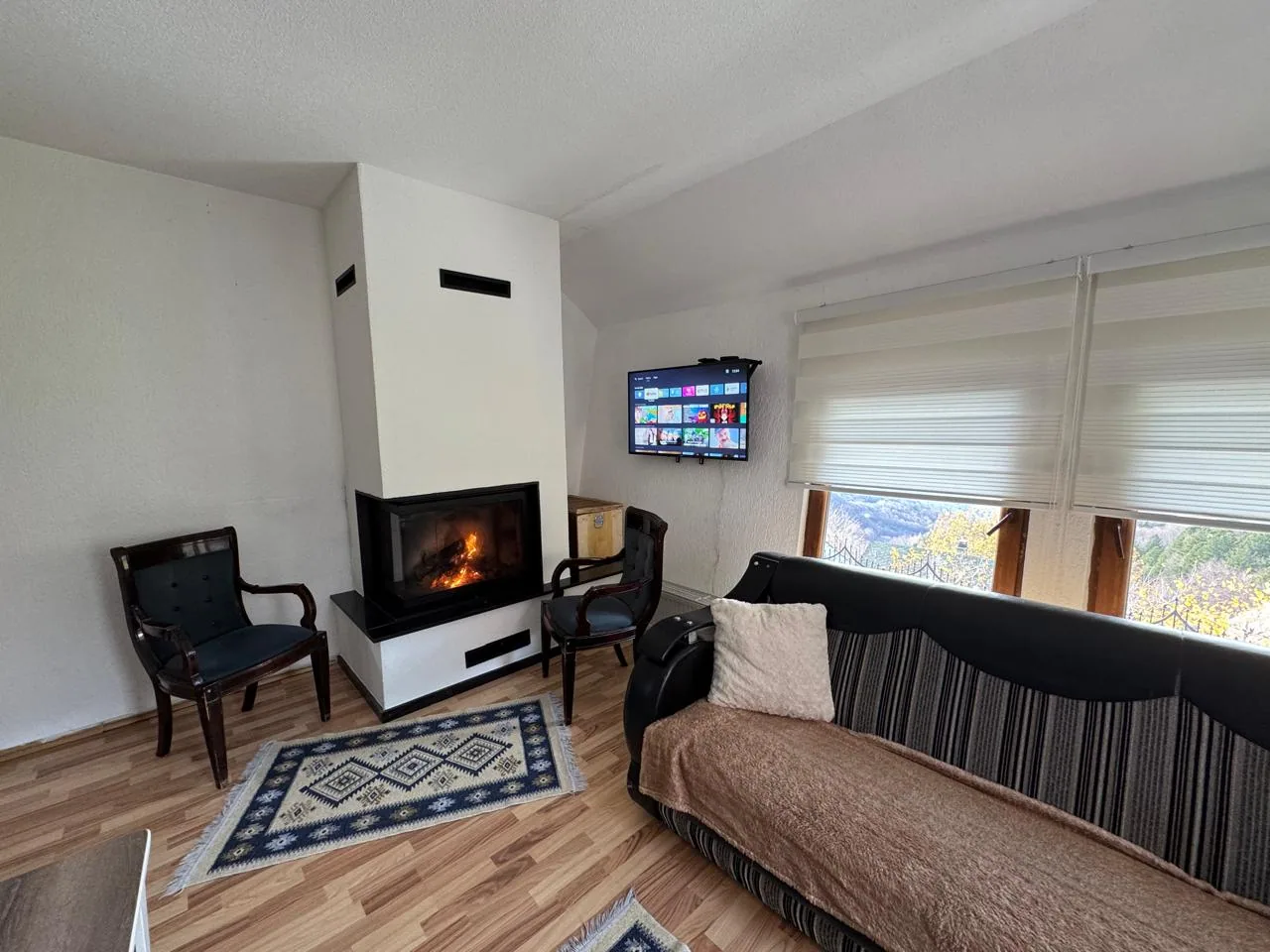 Living room with fireplace in Apartment 2 at Villa Bjeshka